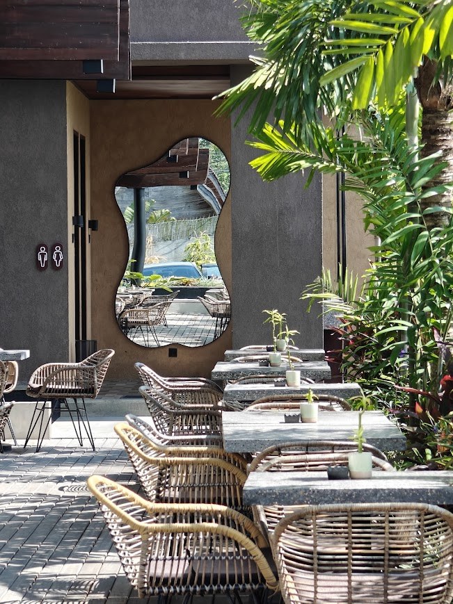 Outdoor dining with rattan chairs and organic mirror