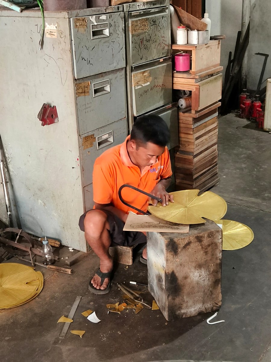 Craftsman hand-finishing brass lotus leaf decorations